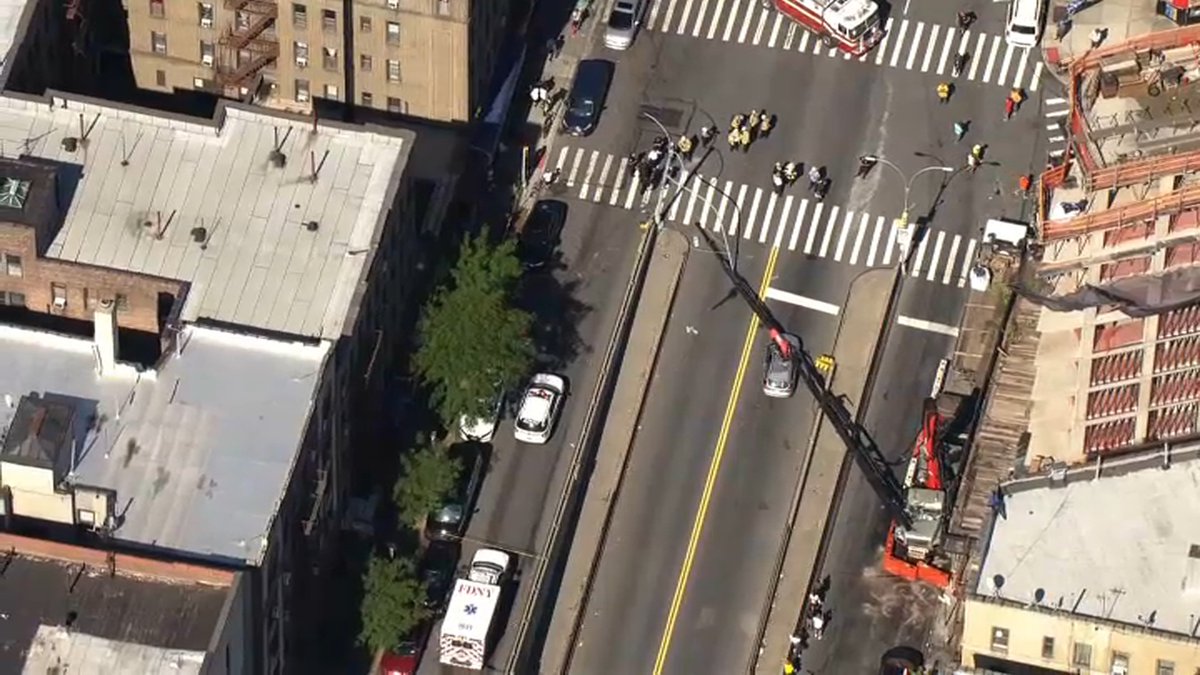 Crane collapses onto a car in the Bronx . a woman in her 20's was inside the car . she was rescued and is conscious and alert 