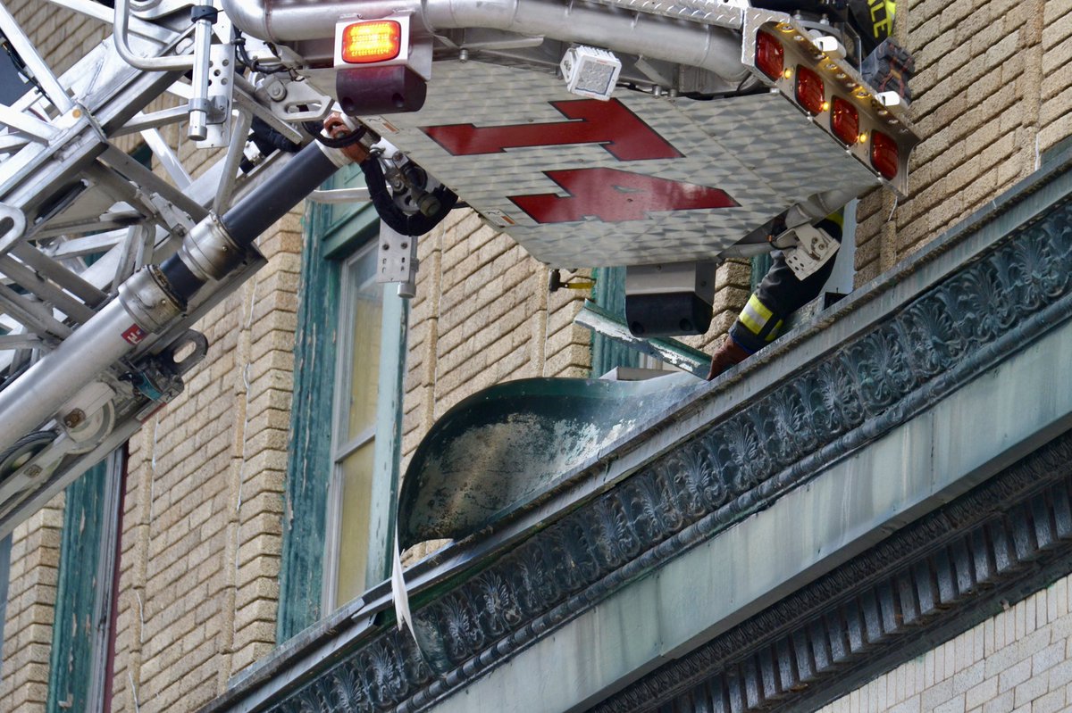 Firefighters from @RFDPIO1 at the former Cadillac Hotel with piece of loose metal blowing in the wind on the 3rd floor. Part of the facade of the building across the street collapsed this past April and was completely removed since