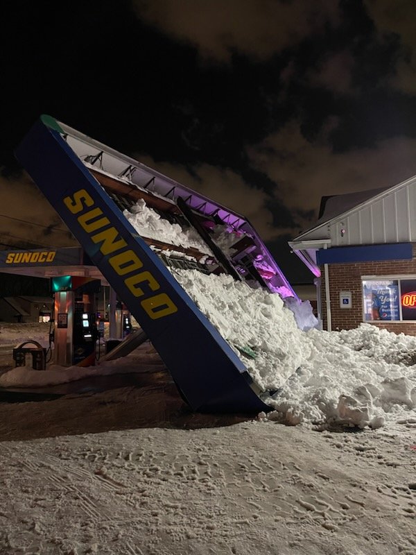 Snow tips over Sunoco sign outside Buffalo